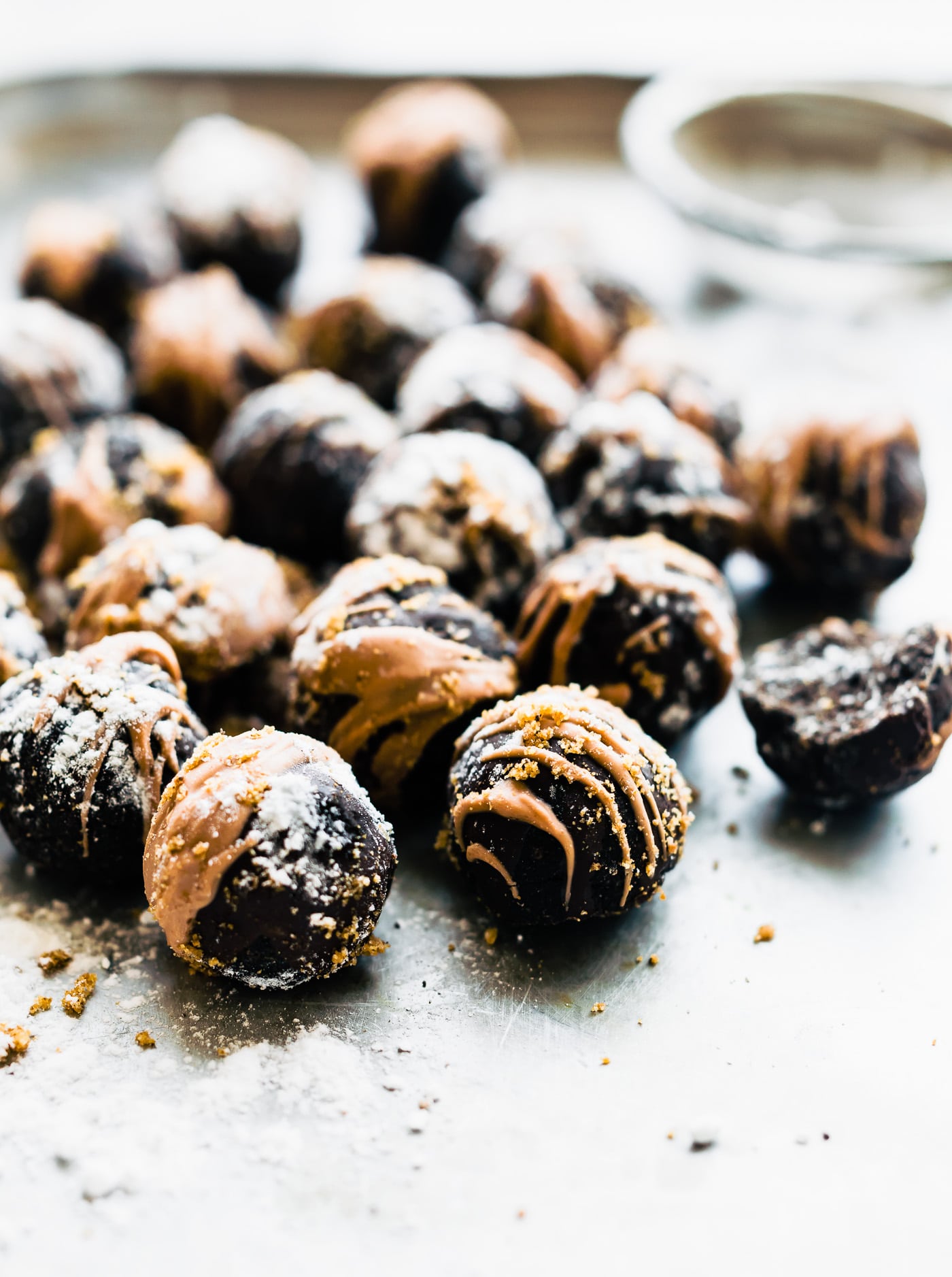 Several Dark Chocolate-Amaretto Cake Bites coated in almond butter and dark chocolate, dusted with crumble.