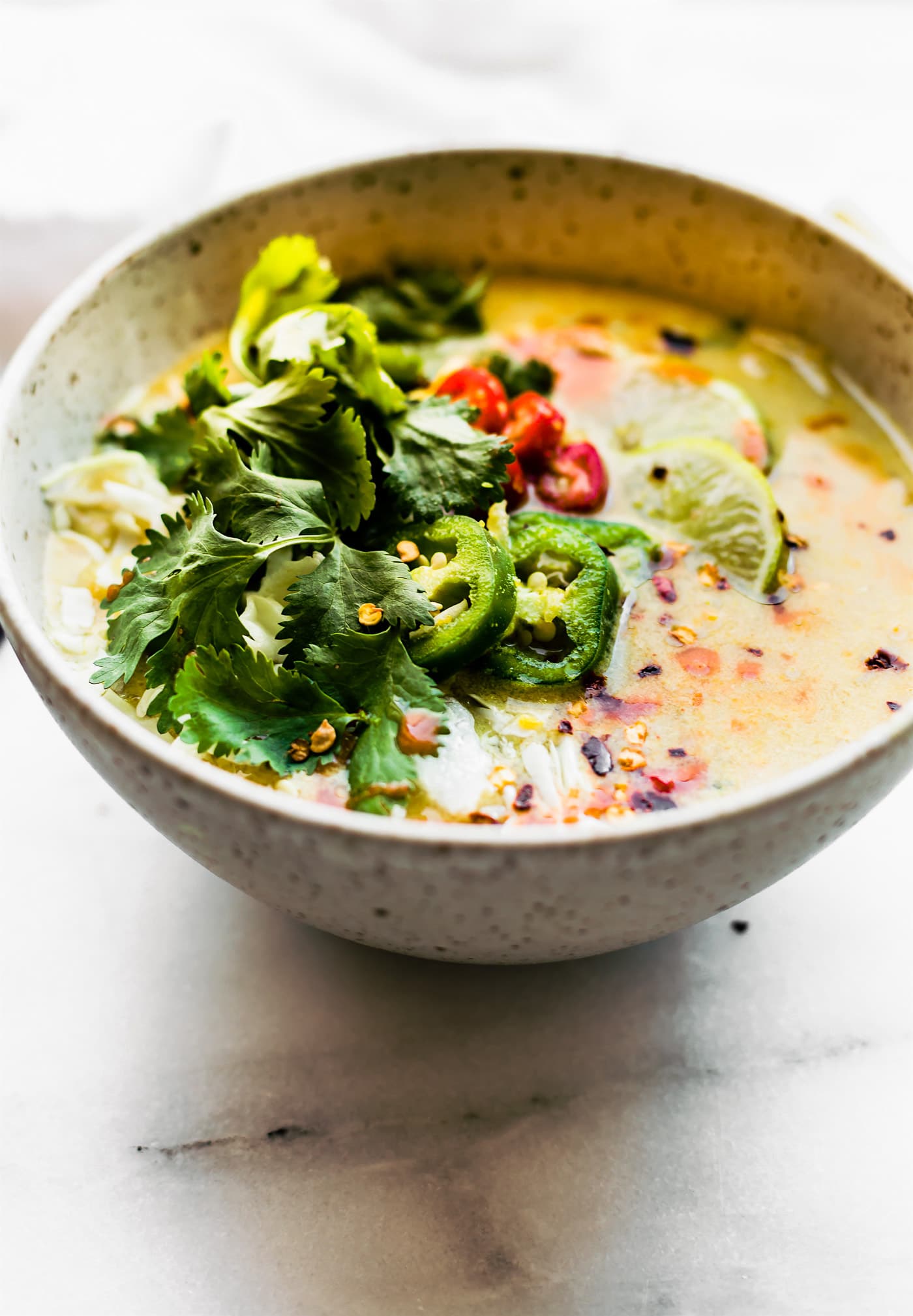 Stone bowl filled with Nourishing Thai Coconut Cabbage Soup topped with fresh cilantro