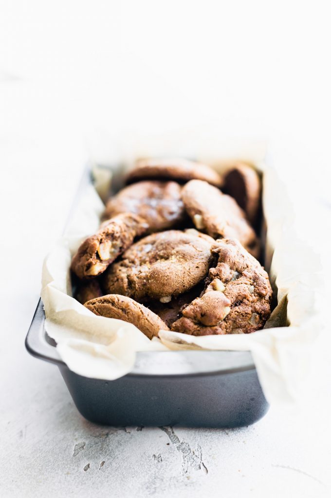 Flourless chewy candied ginger molasses cookies piled in a parchment-lined loaf pan