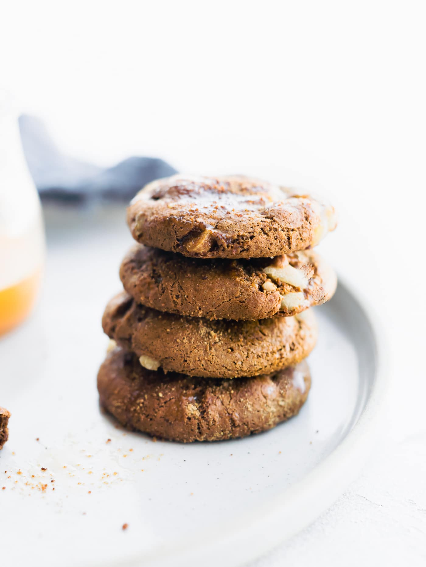 Flourless ginger molasses cookies stacked up on each other on a white plate.