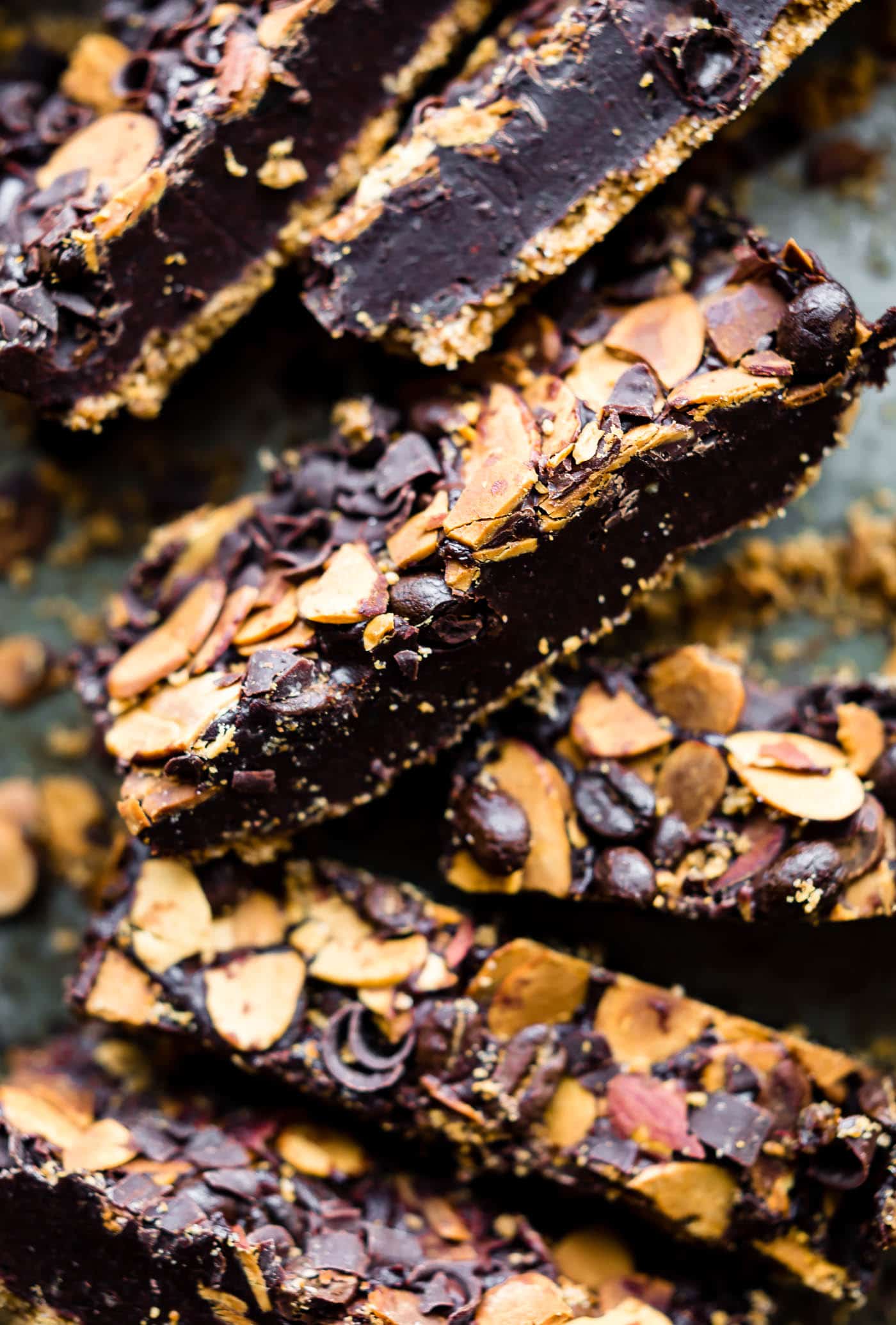 close up image: pieces of vegan mocha almond fudge topped with dairy free chocolate chips and slivered almonds