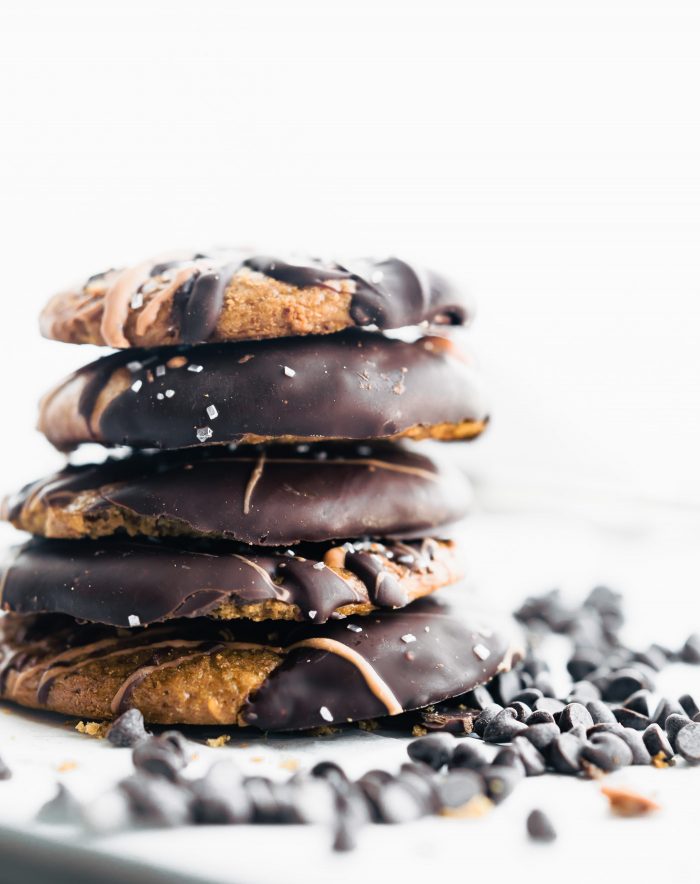 a stack of nut butter Cookies with dark chocolate on top and chocolate chips around it