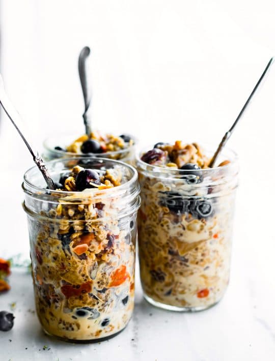 superood instatn pot oatmeal in mason jars topped with berries and served with spoons sticking out of the top