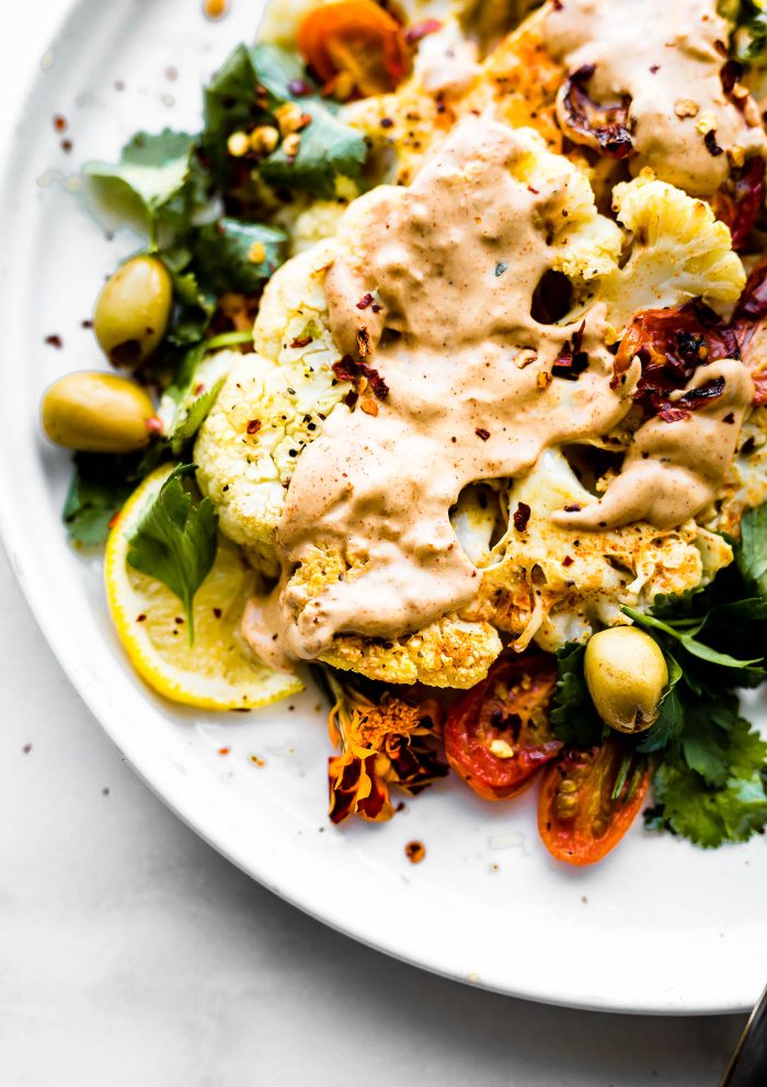 plate of Roasted Cauliflower Steaks topped with Paprika Cashew Cream