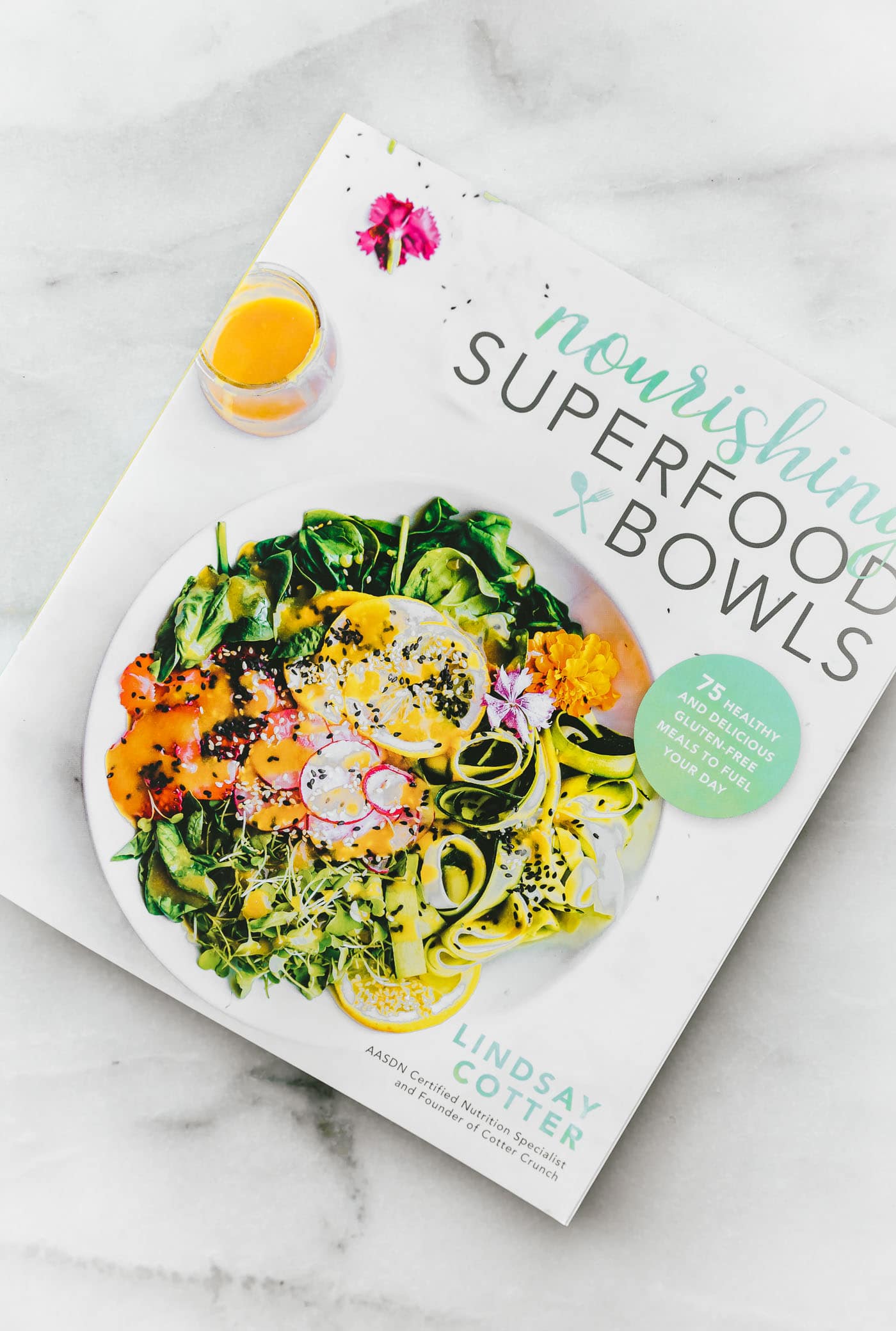 nourishing superfood bowls cookbook on marble background