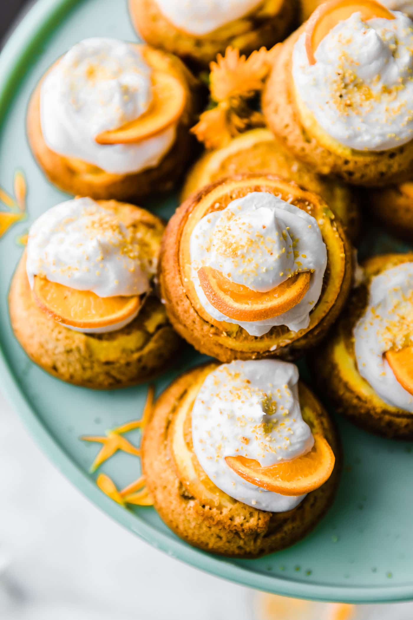 Upside down mini orange cream cakes topped with whipped cream and thinly sliced oranges.