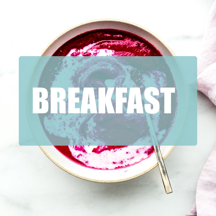 Overhead view vivid fuchsia pink smoothie bowl in white bowl with text overlay for 'breakfast'