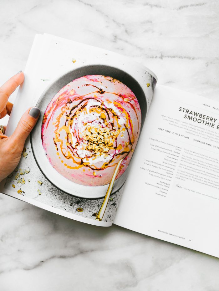 A cookbook open to a strawberry smoothie bowl page.