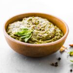 Small wooden bowl filled with pesto sauce.