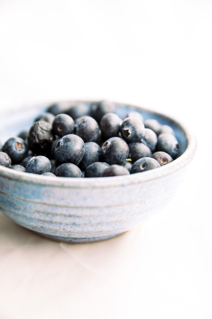 Blue bowl filled with fresh blueberries.