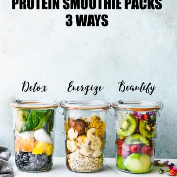 Three glass jars with lids filled with fresh fruits, vegetables, and seeds for protein smoothie packs.