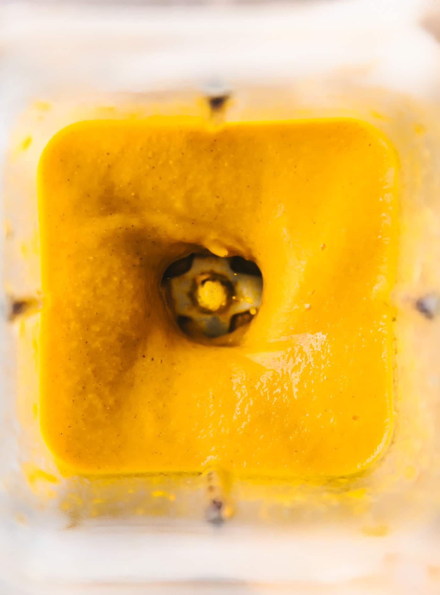 Close up view in blender of smooth orange immunity boosting smoothie.