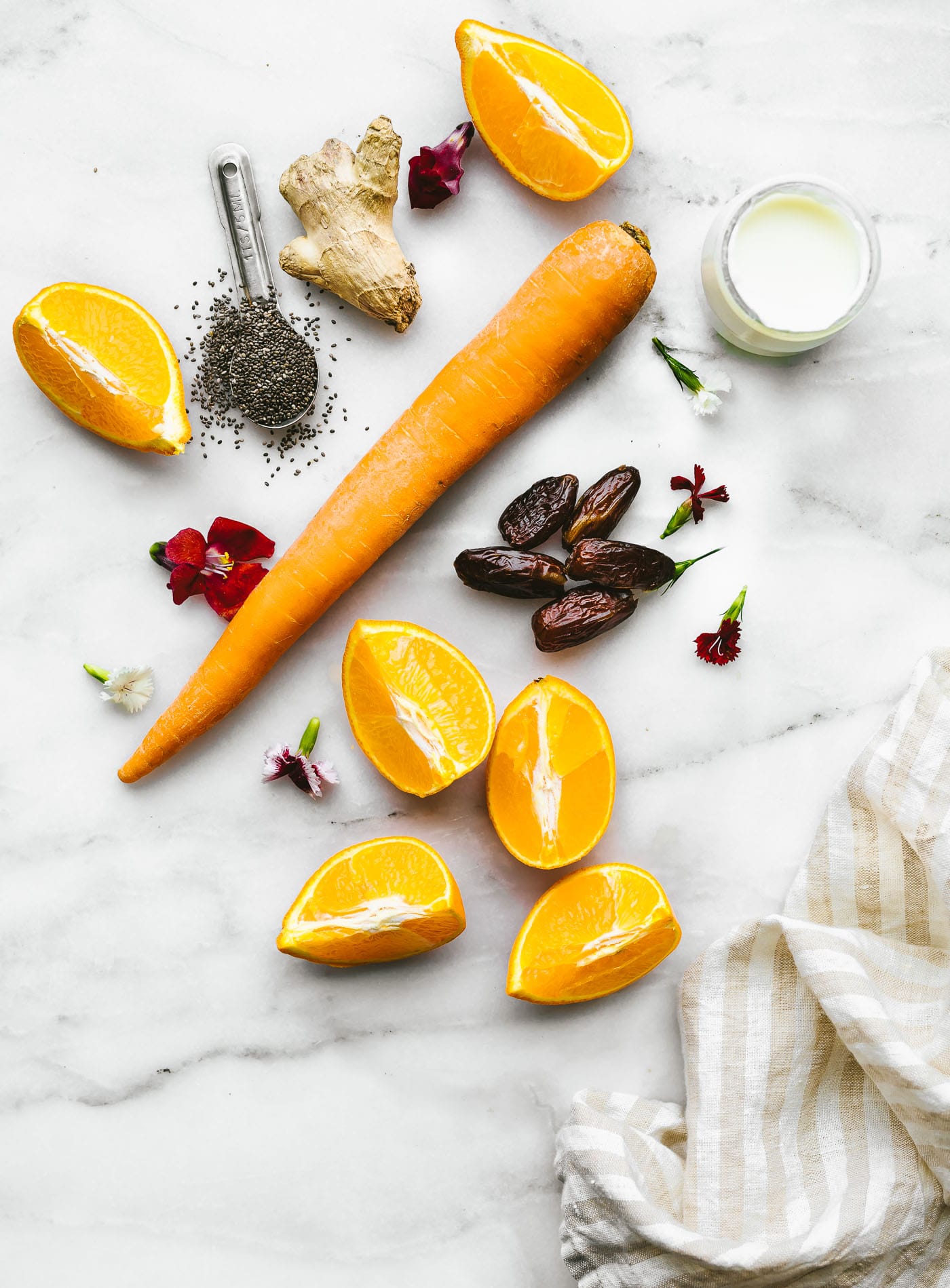 All ingredients for orange probiotic immunity boosting smoothie on marble countertop.