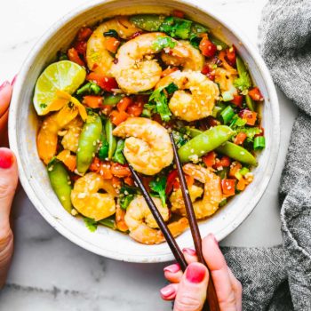 wok fired orange garlic shrimp stir fry recipe! It's full of fresh, snappy Asian flavors and made all in one pan! Shrimp, bell peppers, and snap peas are coated in a delicious spicy honey orange sauce.  Gluten free, Whole 30 friendly, and can be adapted for a paleo version. #stirfry #asian #healthy #onepan #lowcarb #paleo