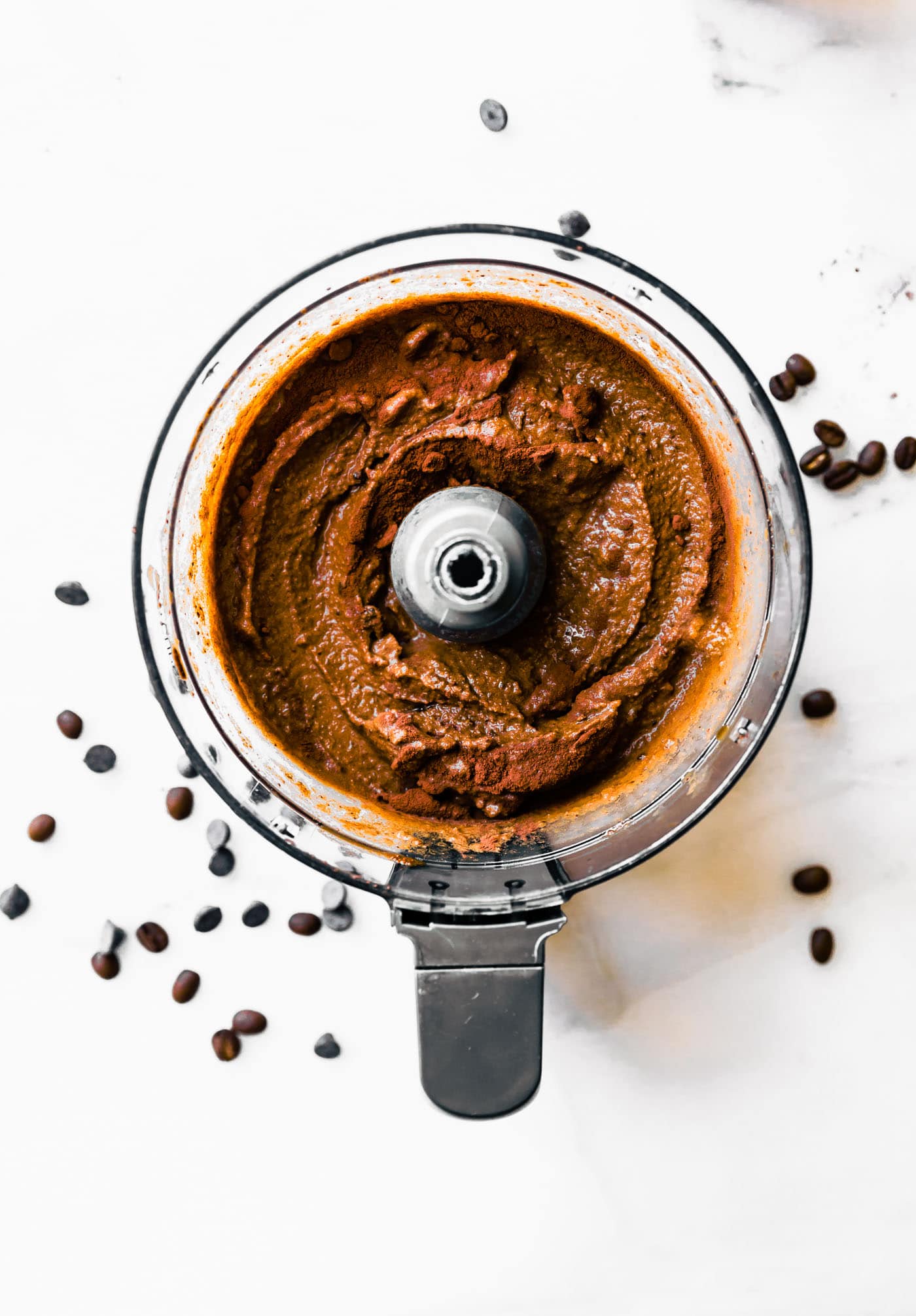 Food processor bowl with dark chocolate espresso sorbet, cocoa powder sprinkled on top.