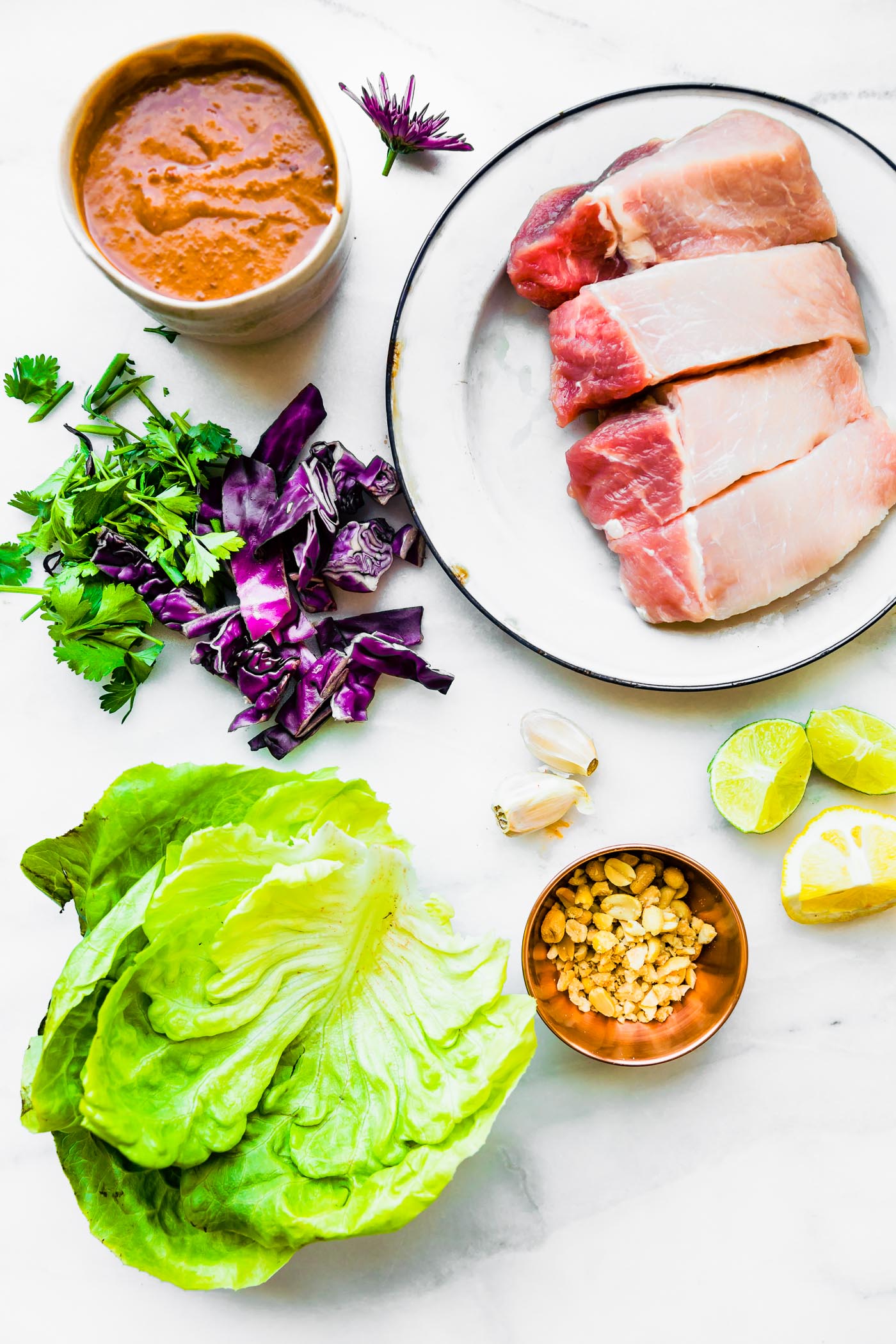 All ingredients for Sticky BBQ Chinese Pork Lettuce Wraps arranged together on plates and in bowls.