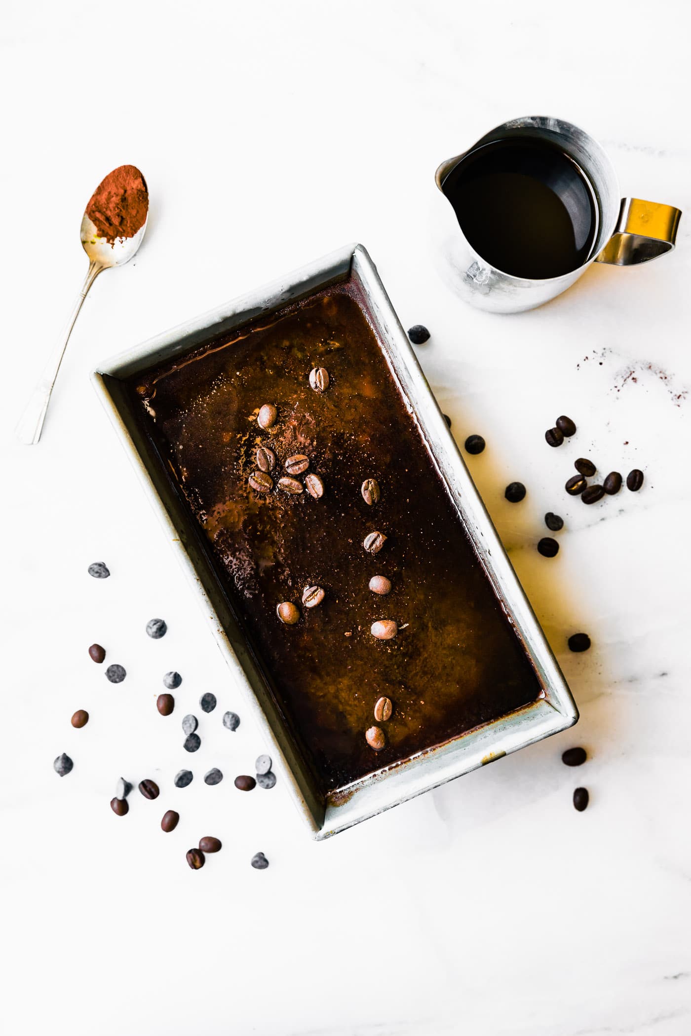 Dark chocolate sorbet in loaf pan topped with espresso beans and cocoa powder.