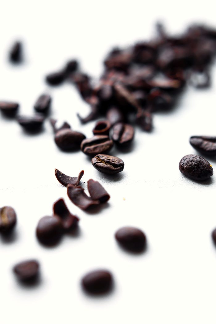 Macro view espresso beans on white background.