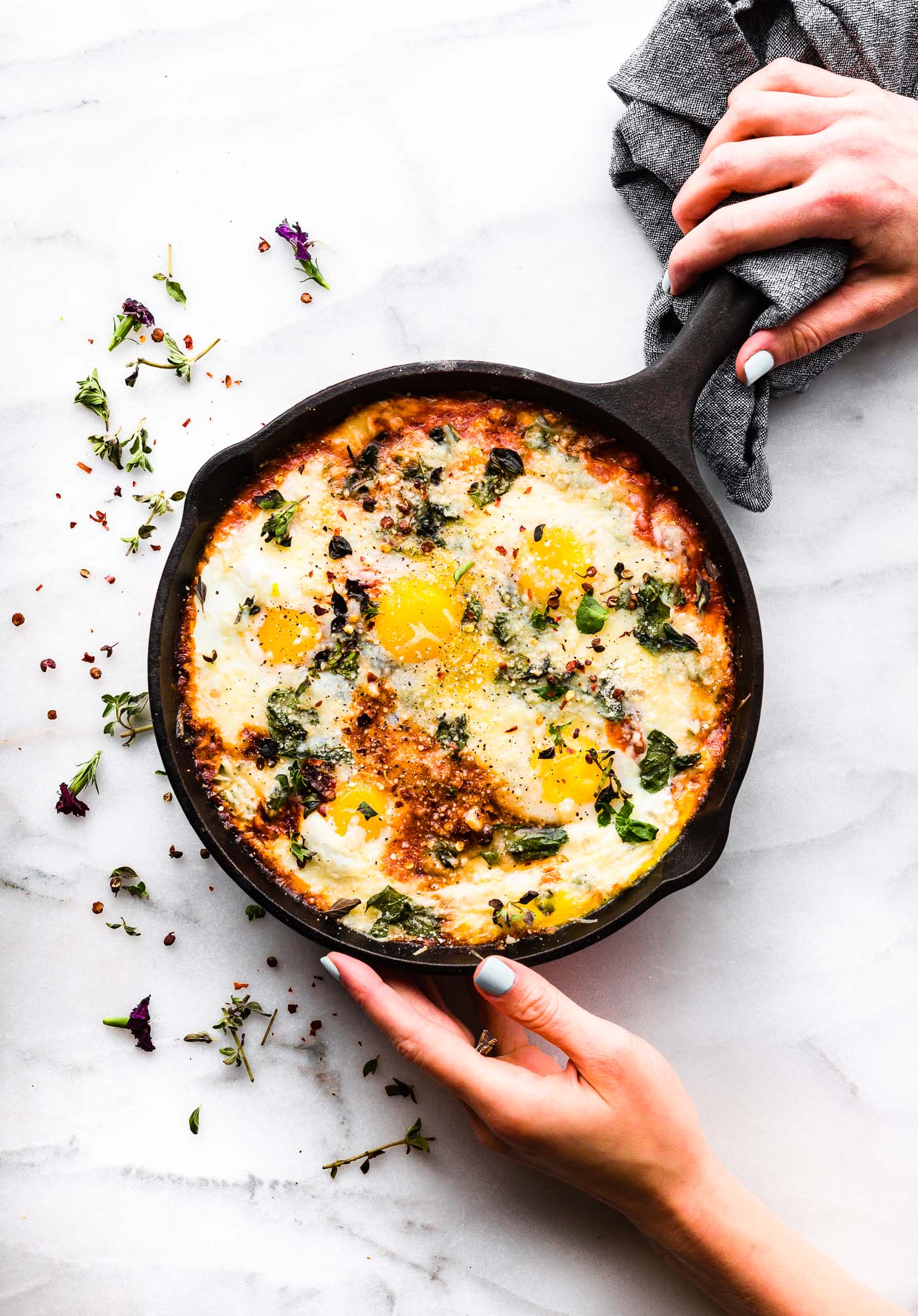 Italian egg bake in cast iron skillet topped with fresh herbs.