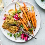 Overhead view plate of pistachio crusted salmon with glazed carrots