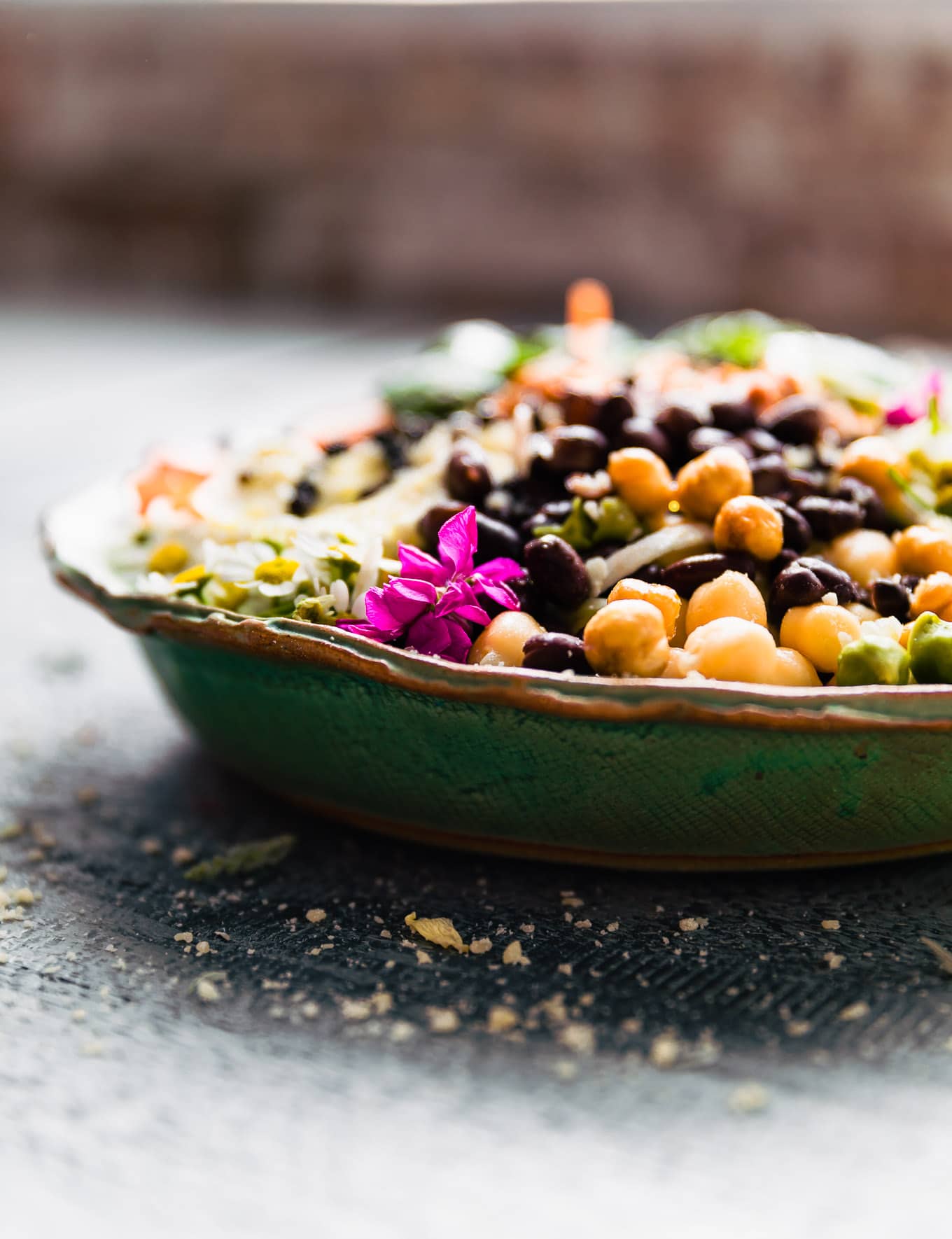 Side view turquoise bowl filled with lentils and salad ingredients