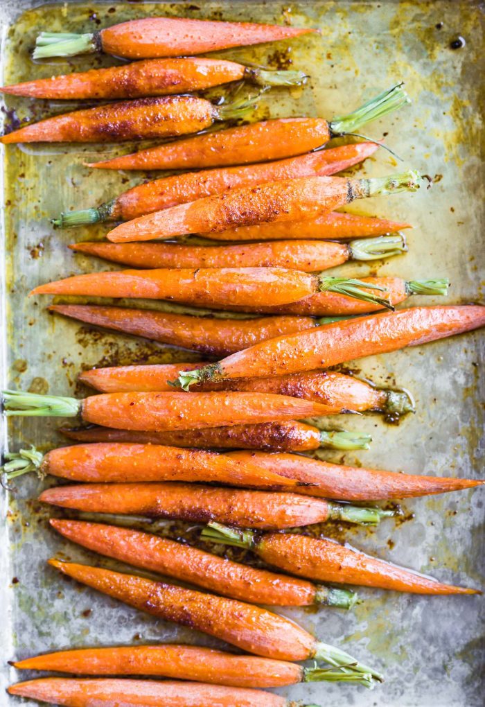 overhead view glazed carrots on baking sheet.