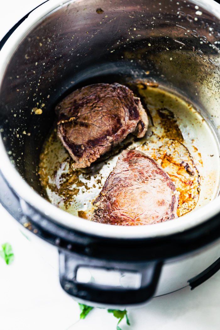 steaks in an instant pot searing for steak fajita soup.