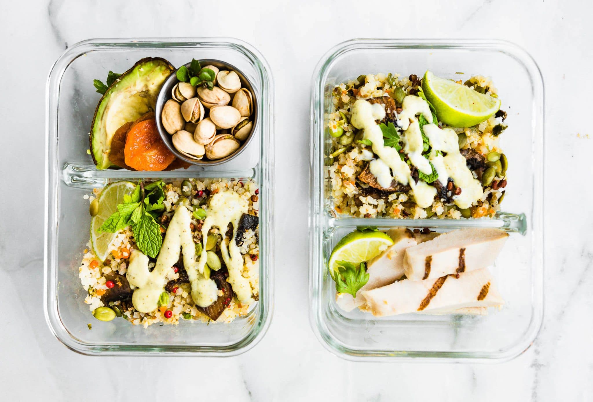 Two meal prep containers filled with Dukkah roasted vegetables and sliced chicken breast.