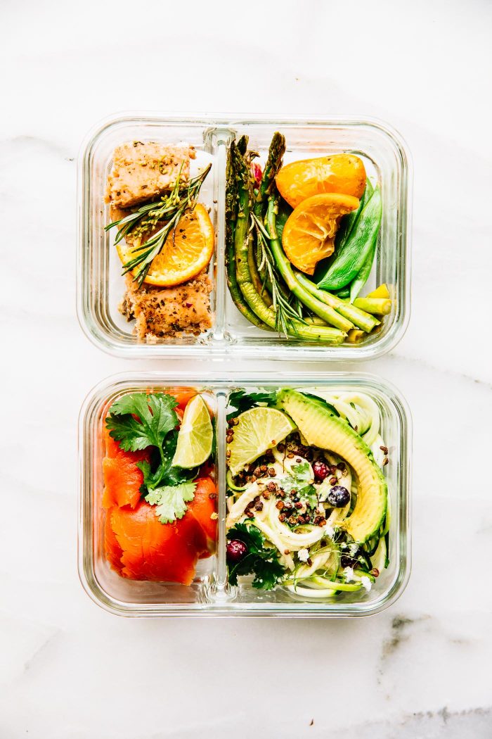 2 meal prep containers filled with rosemary citrus salmon and smoked salmon with zucchini noodles.