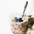 glass of overnight oatmeal made with superfoods, spoon in oatmeal.