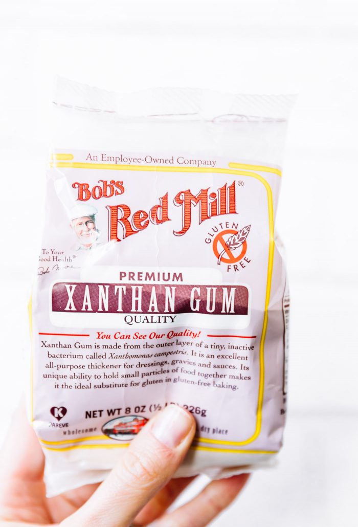 A bag of Bob's Red Mill xanthan gum being held by a hand.