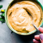 Close up image of chipotle mayonnaise in a bowl with a spoon.