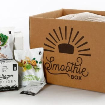 cardboard box with "SmoothieBox" written on the side, with packets of smoothie ingredients
