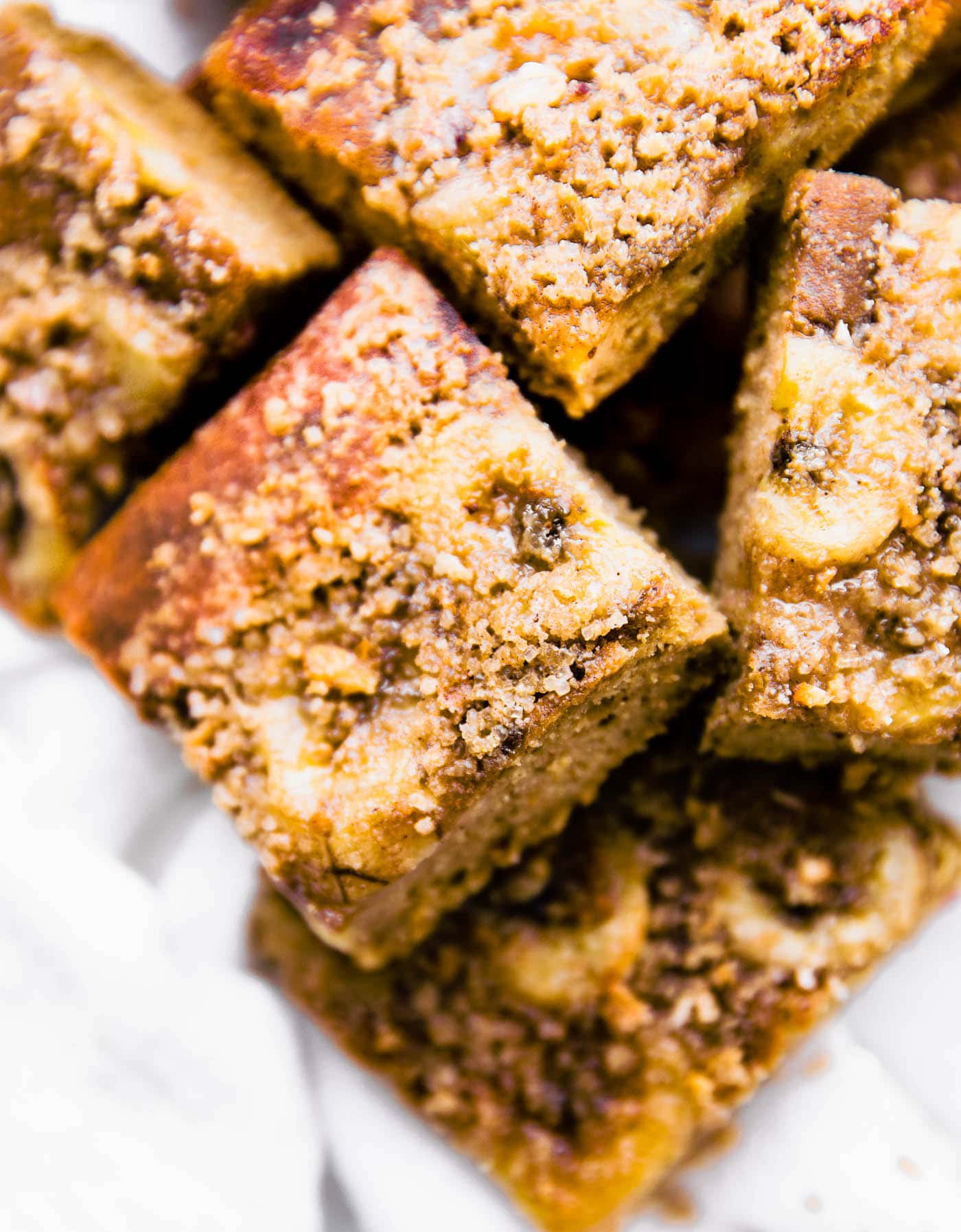 Flourless banana bread bars cut into squares put into a pile, a streusel on top of bars.