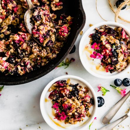 vegan fruit crumble with fresh berries in cast iron skillet
