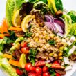 Overhead view Moroccan salad with quinoa and chickpeas and fresh vegetables, in white bowl