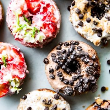 overhead photo: vegan donuts decorated with allergy-friendly toppings (dairy free chocolate chips and fresh strawberry slices)