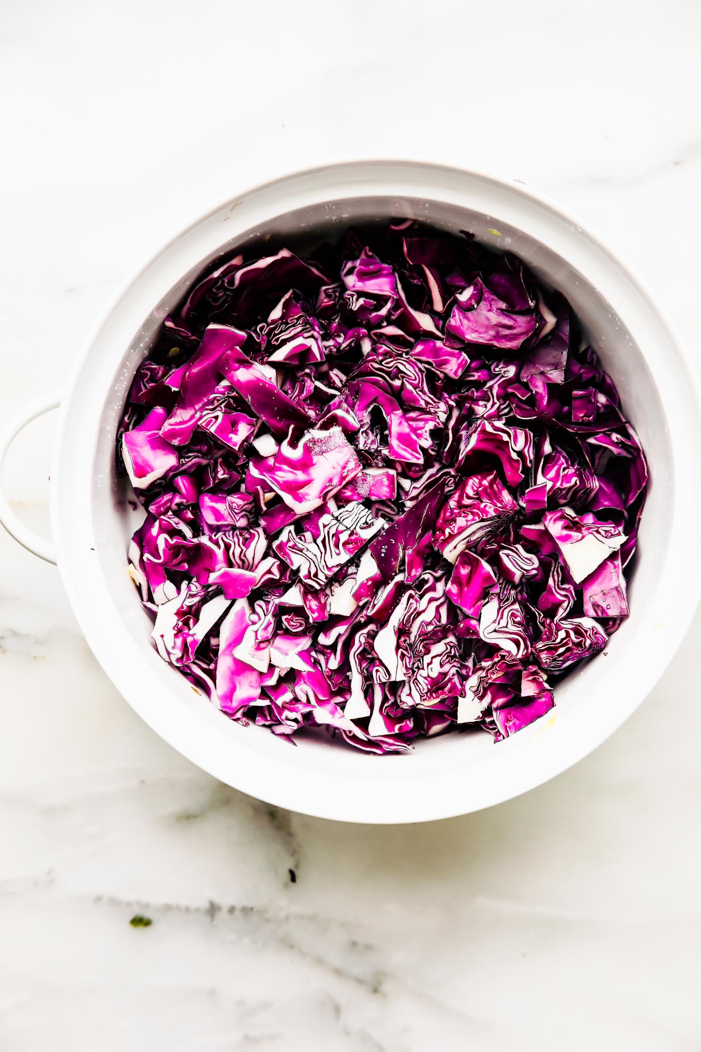 Overhead view shredded purple cabbage in white bowl