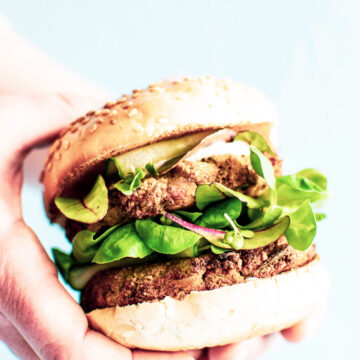woman's hand holding a vegan veggie burger