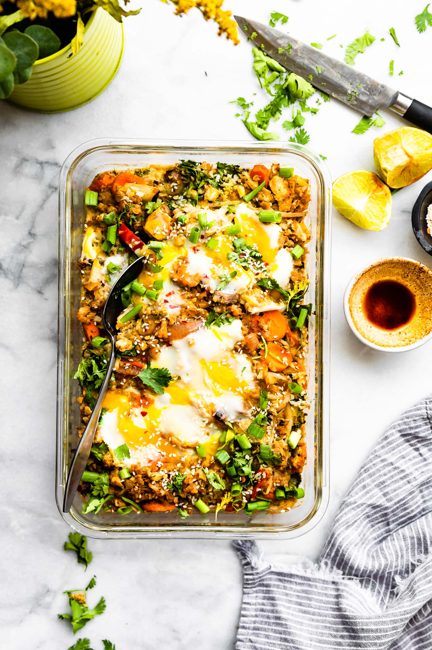 Overhead view baking dish filled with Chinese cauliflower fried rice casserole with fried eggs on top.
