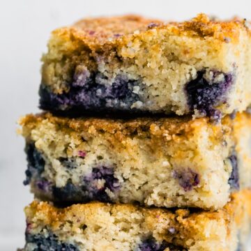 3 squares of blueberry buckle cake stacked on top of each other.