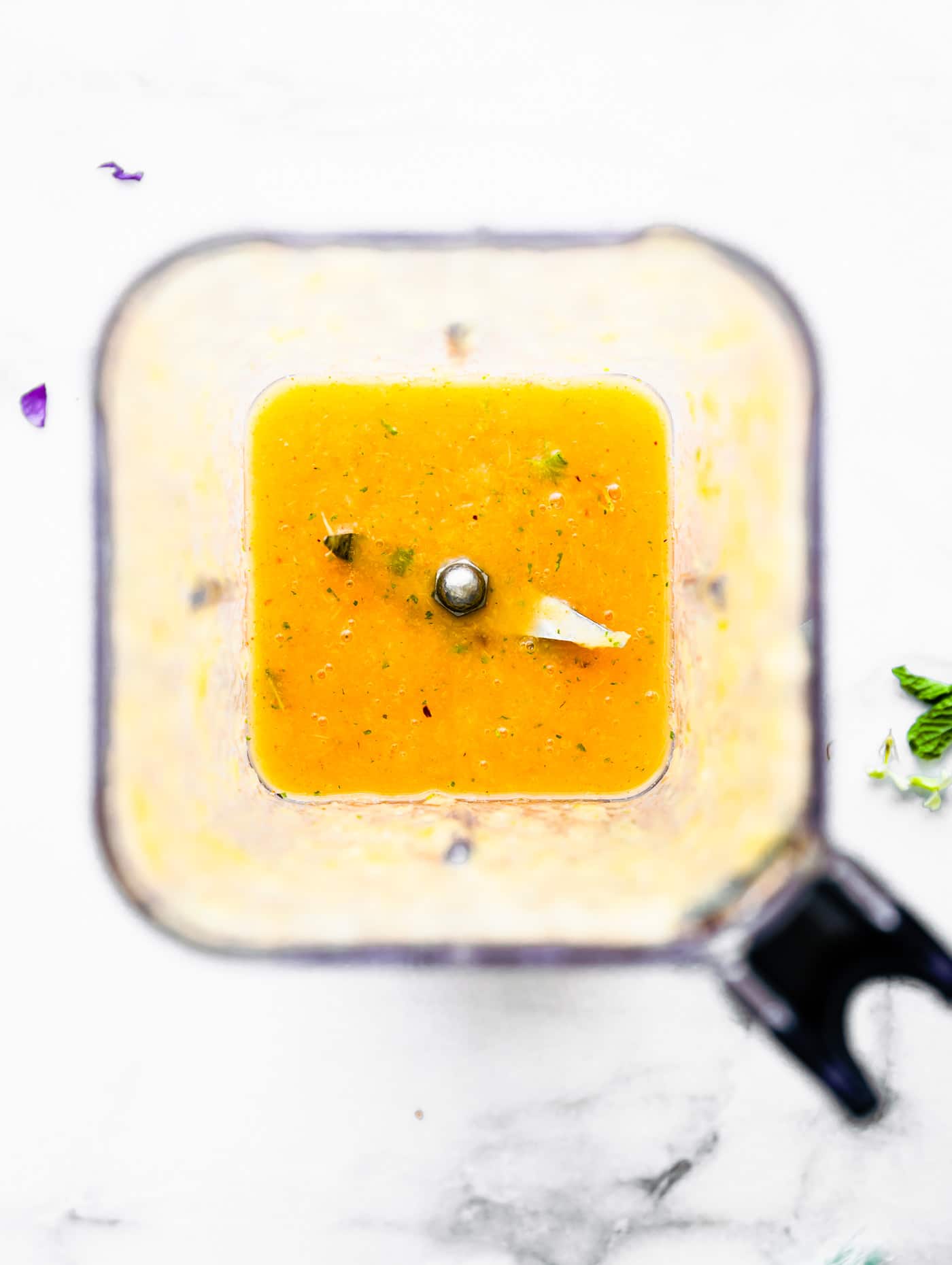 Overhead view high speed blender filled with pineapple turmeric puree.