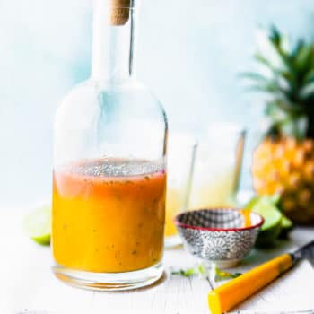 Turmeric pineapple cocktail in tall glass with short glasses