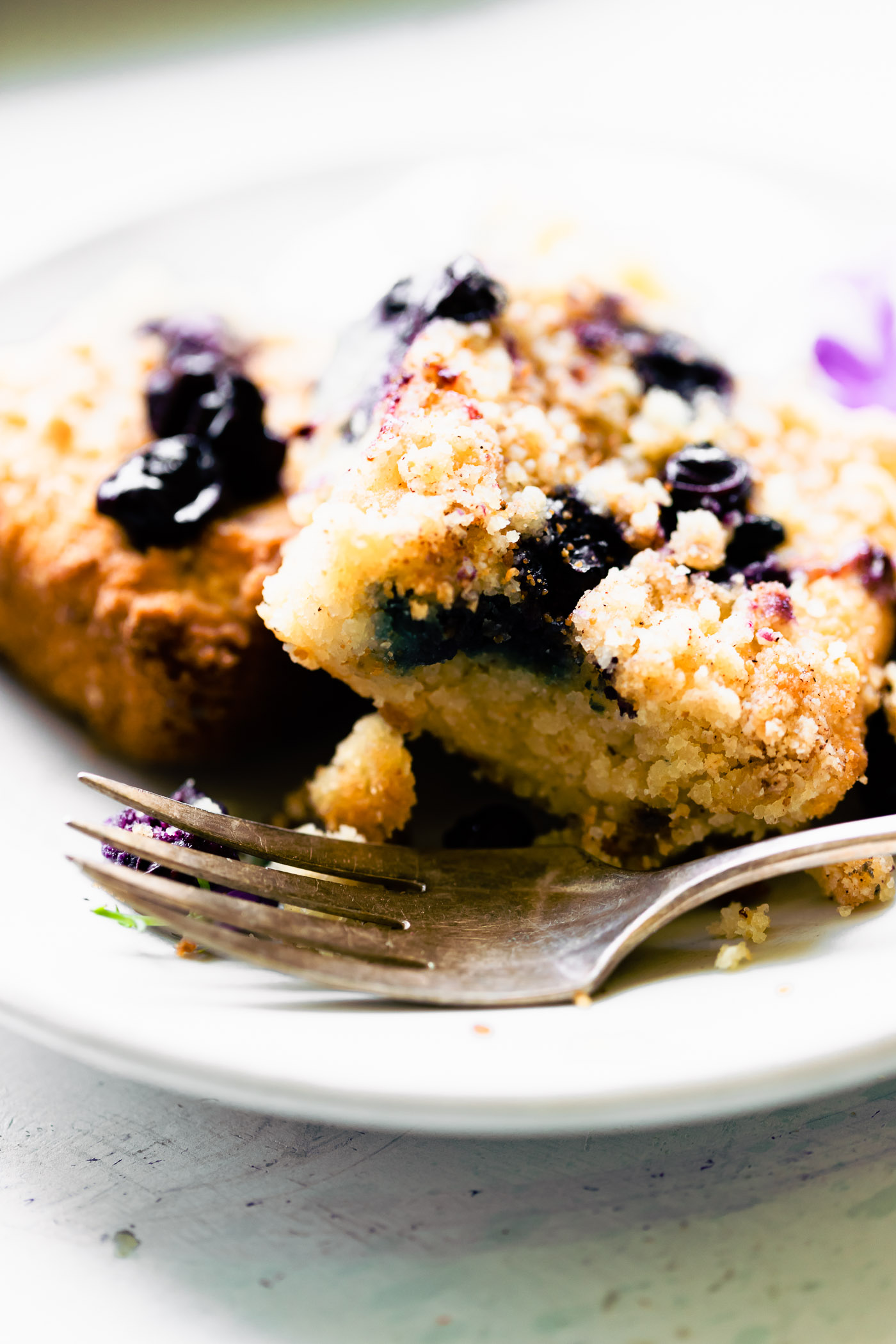 Squares of blueberry buckle coffee cake on white plate.