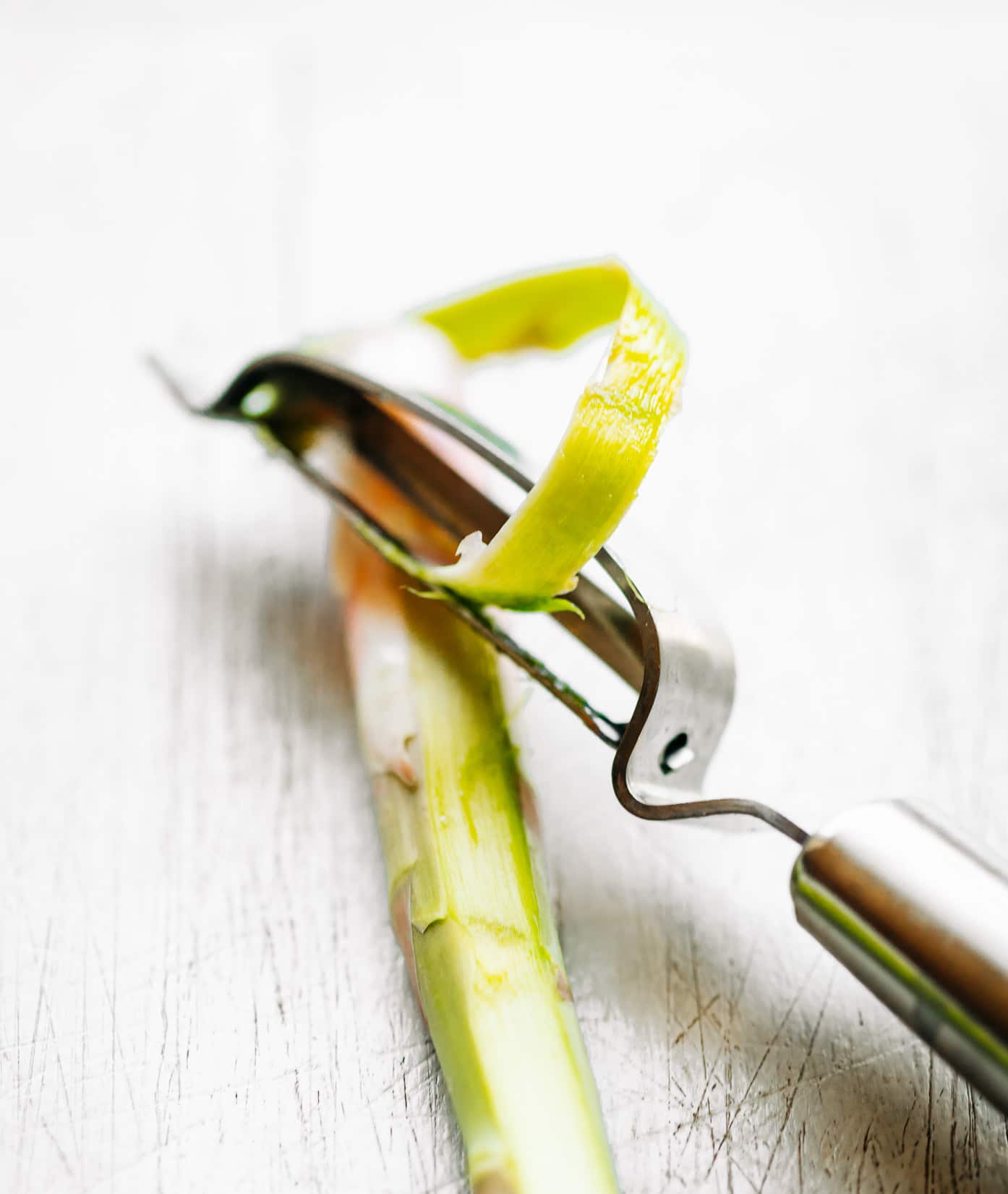 A potato peeling peeling an asparagus stalk.