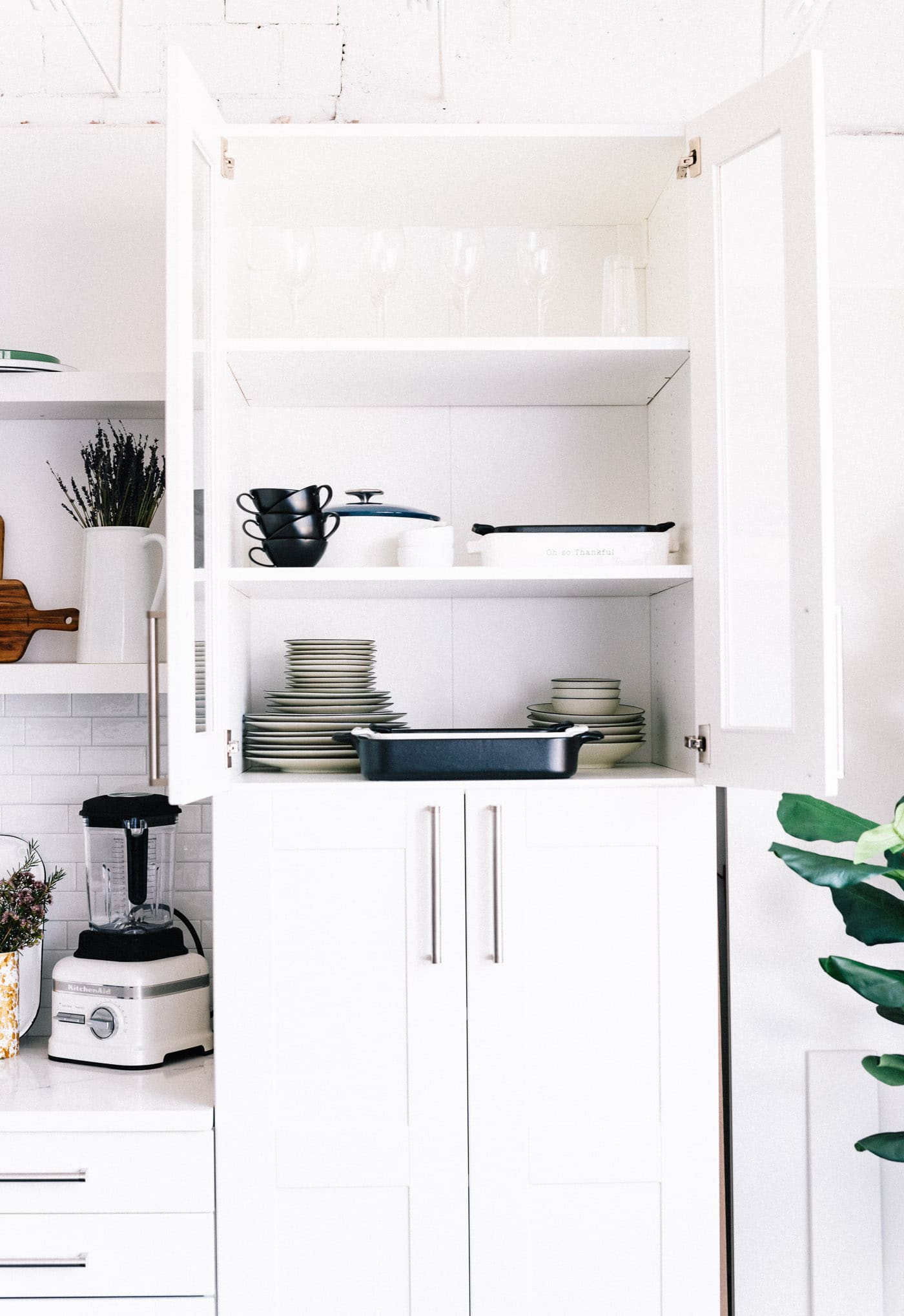 cabinets in studio, white and filled with baking dishes.