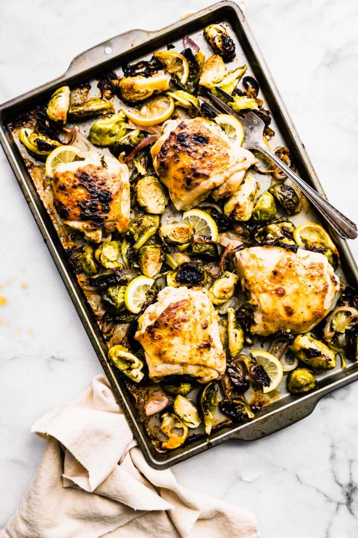 Overhead view of honey mustard chicken with Brussels sprouts roasted and served on a sheet pan.