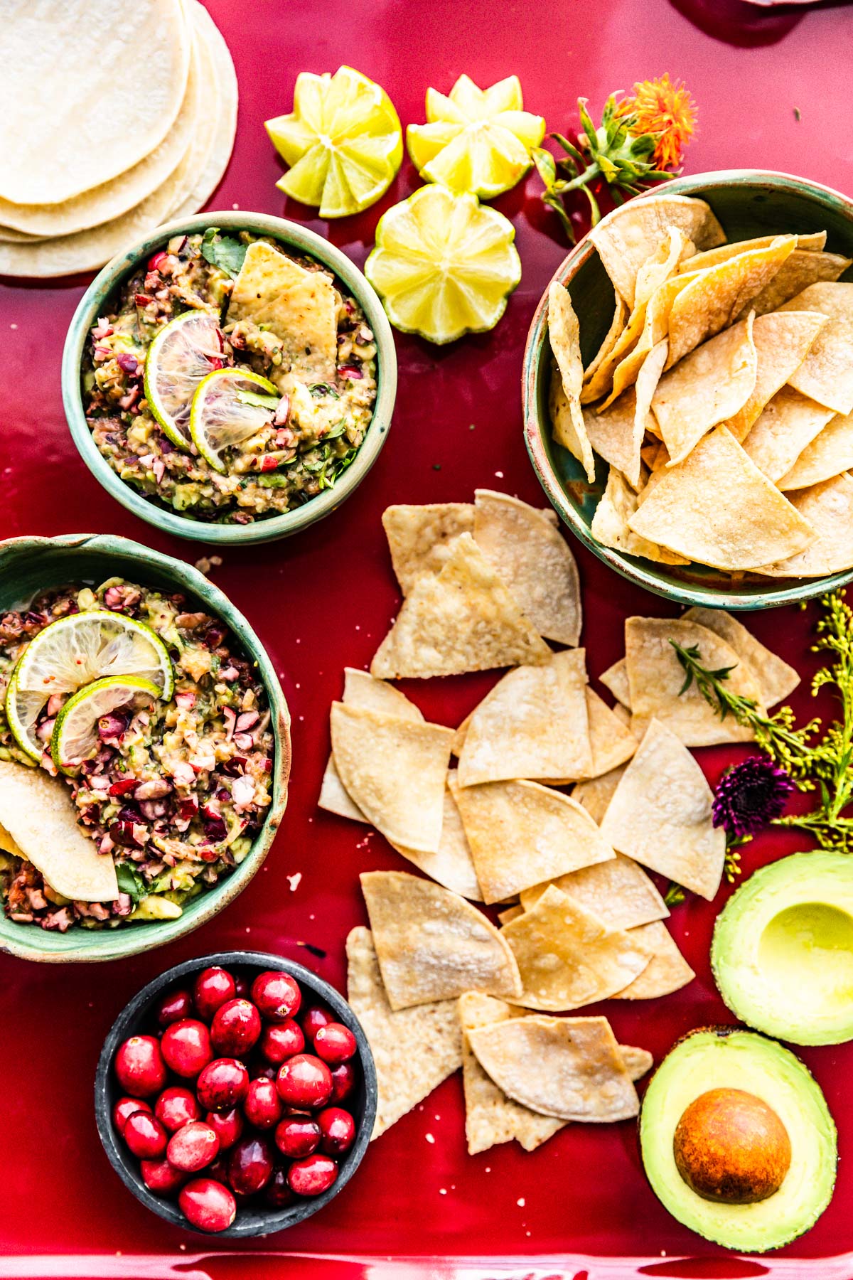 Overhead view avocado cranberry salsa in bowls with stone baked tortilla chips in bowl