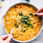 hands dipping chips into roasted jalapeno hot crab dip