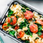 keto chicken dinner with spinach and tomatoes in meal prep container
